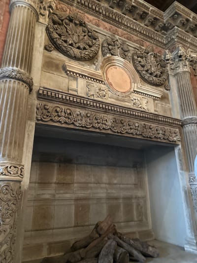 The image shows a detailed view of ornate architectural elements, likely part of a building's facade or interior in Tlalnepantla, Mexico. The architecture features carved stone, decorative columns, and intricate moldings. The right side shows a recessed area with stone walls and what appears to be wooden planks or beams piled within the space. There are no people visible.