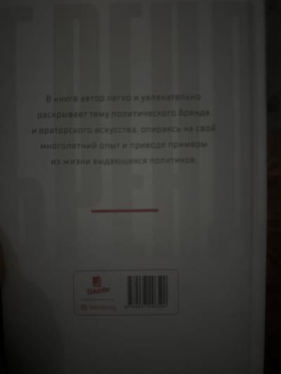 The image displays the back cover of a book. The text on the cover is in Russian and describes the book's content: "In the book, the author easily and engagingly reveals the topic of political branding and oratorical art, drawing on his many years of experience and providing examples from the lives of prominent politicians." Below the text, there is a red horizontal line. Further down, a logo with the text "Toktobo" is visible, along with a website address "toktobo.kg" and a barcode with the numbers "9789674388590". The background appears to be a light-colored surface, likely the book cover itself, with vertical lines that could be part of the design or a shadow effect. The image does not provide any information or context related to the city of Sadovoe, Kyrgyzstan.