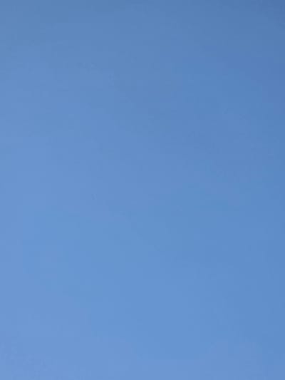The image shows a clear, bright blue sky. There are no discernible objects, people, or environmental features visible in the frame. The lighting suggests it is daytime, likely under sunny conditions. The scene is devoid of any urban or natural elements that would indicate a specific location in the city of Жал, Kyrgyzstan.