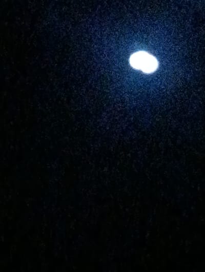 The image is a dark, blurry photograph with a bright, white oval-shaped light source in the upper right quadrant. The background appears to be textured and dark, possibly representing a night sky or a dimly lit environment. There are no discernible people, objects, or specific environmental features identifiable in the scene. The location in Daşoguz, Turkmenistan cannot be determined from the visual information provided.