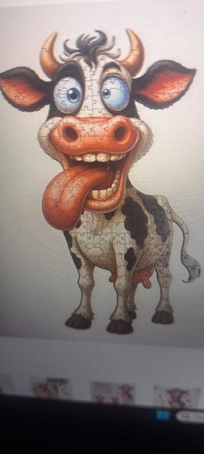 The image is a puzzle of a cow. The cow has large blue eyes, a gaping mouth with a large tongue, and black and brown spots. The puzzle pieces are visible throughout the image. The location is not identifiable from the image.