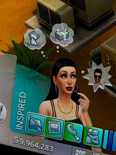 The image displays a digital screen showing a video game interface. The central subject is a female avatar with long dark hair, blue eyes, and red lipstick, wearing a black camisole, a gold necklace, and hoop earrings. She is depicted with her right hand raised, index finger extended, and a vertical teal banner to her left reads "INSPIRED." Above her head, three thought bubbles are visible: one containing a toilet icon, another showing stacks of money with sparkle effects, and a third depicting the headshot of a male avatar with sunglasses and a beard, set within a starburst shape.
Below the character, a currency display shows "$9,964,283." To the right of this, a horizontal row of four visible square icons includes: a spoon and plate, an easel with a painting, a bitten chicken drumstick, and two embracing figures. Further right, a partial view of blue vertical progress bars is present.
The background of the game environment features an isometric view of arid, sandy terrain with some green foliage visible behind the female avatar. Several beige or light brown industrial-style buildings with large ventilation or air conditioning units on their roofs are also present. The scene is entirely within a fictional digital realm. No discernible real-world geographical markers are present to link the image to Hallandale Beach, United States.