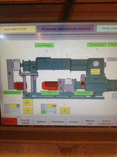 The image shows a close-up of a digital control panel for an industrial machine, likely a brick press, as indicated by the Russian text "Установка прессования кирпича" (Brick pressing installation). The panel displays a schematic diagram of the machine with various components highlighted and labeled with Russian text.

Key elements visible on the panel include:
*   **Date and Time:** "04.07.2026 3:15:55"
*   **Status Indicators:** Green buttons labeled "Подача материала" (Material feed) and "Вакуумный клапан" (Vacuum valve), and a yellow box labeled "Вакуум достигнут" (Vacuum reached).
*   **Machine Schematic:** A simplified line drawing of a large industrial machine with visible components like motors, shafts, and a pressing mechanism.
*   **Numeric Displays:** Several boxes with numerical values and percentages, such as "35 %", "0 %", "0 A", "1", "-1", and "100 %".
*   **Bottom Menu Bar:** Buttons labeled "Ошибки" (Errors), "Очистка экрана" (Screen cleaning), "Графики" (Graphs), "Параметры" (Parameters), "Система" (System), "Рабочий стол" (Workstation), and "Кнопки управления" (Control buttons).

The environment appears to be industrial, with the control panel likely situated in a factory or production facility. The image quality suggests it was taken with a mobile phone camera, and there are some dust particles visible on the panel and the surrounding equipment, which is common in such settings.

The location "Рэчыцкі сельскі Савет, Belarus" is a rural administrative region in Belarus. While the image itself doesn't contain any visual cues to confirm this specific location, it describes the context in which such industrial equipment might be found.