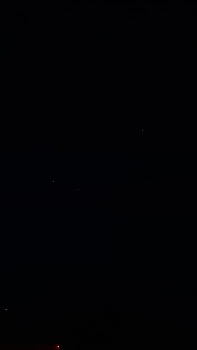 The image shows a dark night sky with a few stars visible. In the lower right corner, there are faint red and green lights. The location is Шешурга, Russia.