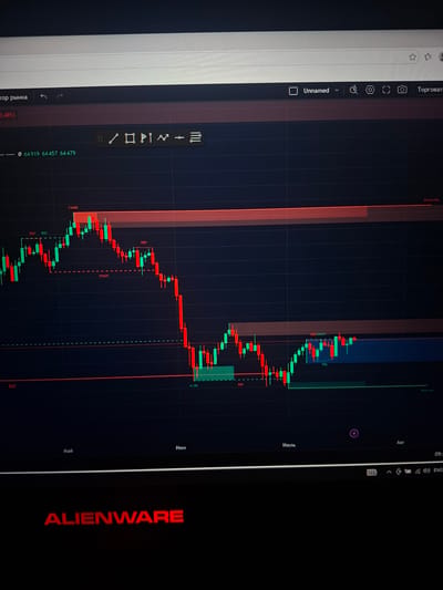 The image displays a close-up view of a computer monitor showing a financial trading chart. The chart features Japanese candlestick patterns, with red and green candles indicating price movements over time. Various horizontal lines and colored zones are overlaid on the chart, likely representing support and resistance levels or other technical indicators. Text labels such as "EQH", "BOS", "CHoCH", "Weak High", and "Weak Low" are visible, suggesting technical analysis concepts. The date axis at the bottom shows month labels: "Май" (May), "Июнь" (June), "Июль" (July), and "Авг" (August). The top bar of the browser window shows a tab labeled "Unnamed" and other icons. In the foreground, the "ALIENWARE" logo is prominently displayed in red, indicating the brand of the computer. The setting appears to be indoors, with the monitor being the primary subject. There are no discernible elements that would place this image in or associate it with Užuežerė, Lithuania.