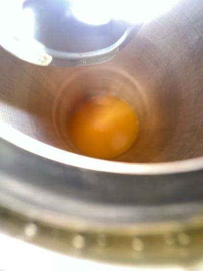 An amber-colored, spherical object sits inside a cylindrical metal container. The container appears to be indoors. The background is out of focus. There are no visible people. There are no identifying landmarks suggesting Grange Ville, Ireland.