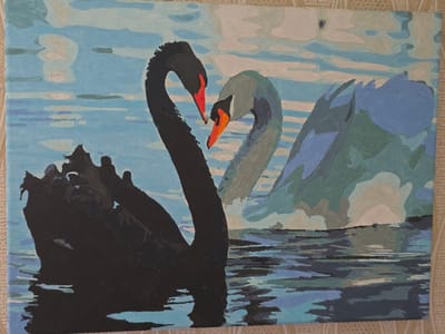 The image is a painting of two swans on a body of water, likely a lake or river. The swan in the foreground on the left is black with a red beak, and its neck is curved to form a heart shape towards the swan on the right. The second swan is lighter in color, appearing to be a pale grey or white, also with an orange beak. Its neck is also curved towards the black swan, completing the heart shape. Behind these two swans, another swan or a reflection of a swan is visible, rendered in shades of blue and green. The water is depicted with horizontal brushstrokes in various shades of blue, grey, and white, suggesting ripples and reflections. The background is a sky with clouds, painted in light blue and white. The overall impression is one of serenity and connection between the two swans. The painting style is somewhat abstract, with distinct blocks of color. There is no visible text in the image. The scene is likely set during daylight hours, with the light reflecting off the water and clouds.