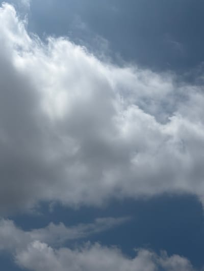 A close-up, vertical shot captures a sky filled with a mix of bright white and dark gray clouds against a backdrop of deep blue sky. The clouds are dense and textured, with some appearing wispy and others thick and voluminous. Light seems to be filtering through some of the lighter clouds, creating a subtle glow. The overall impression is of a dynamic and overcast sky. The image was taken in Grapevine, United States of America, and does not contain any people, specific landmarks, or discernible actions.
