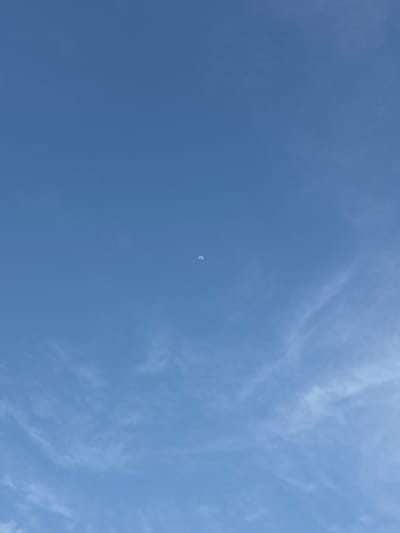 A daytime wide shot reveals a blue sky with thin, wispy clouds scattered across the right side. A small crescent moon is visible in the center of the frame. The image appears to be taken outdoors, likely in Boca del Río, Mexico, though there are no identifying landmarks to confirm the specific location within the city. No people, subjects, objects, actions, or interactions are visible other than the sky, clouds, and moon.