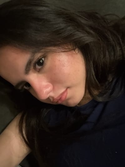 A close-up, slightly rotated image shows a person with dark hair, light skin, and dark eyes. The person is likely lying down, given the angle of the shot. A dark blue shirt is visible. The specific location in College Station, United States of America, cannot be determined from this image alone.