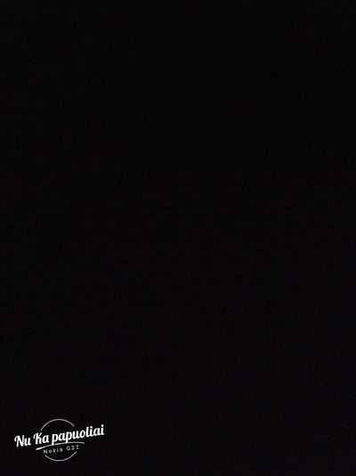 The image is a dark, black screen with white text at the bottom. The text reads "Nu Ka papuoliai" in a stylized font, with "Nokia G22" below it in a smaller, plainer font. The text is centered horizontally and positioned in the lower half of the image. There is a circular outline around the text "Nu Ka papuoliai". The background is entirely black and shows no discernible features of the city of Stockton-on-Tees, United Kingdom.