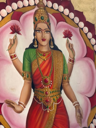 This image depicts a finely detailed painting of a four-armed female deity, likely Lakshmi, centrally positioned against a stylized backdrop of pink lotus petals, a red border, and an outer golden frame with white oval adornments. The deity has dark skin, brown eyes, a red bindi on her forehead, and a gold nose ring with a white pearl. Her dark hair flows over her shoulders. She wears an elaborate golden crown with green and red gemstones, a green short-sleeved blouse, and a red saree-like garment. Numerous pieces of intricate golden jewelry, including multiple necklaces with red and green gemstones and pearls, large earrings with pearl tassels, armbands with green gems, and beaded bracelets in white and red, adorn her. A prominent golden waist belt featuring red and green gemstones and pearls is also visible. Her upper two hands each hold a red lotus flower by its stem, raised approximately to shoulder height. Her lower left hand is extended with the palm facing forward and fingers slightly curled in a gesture of giving. Her lower right hand also extends forward with the palm open, displaying a sun-like symbol on the palm. The artwork does not visually depict its specific location within Briançon, France.
