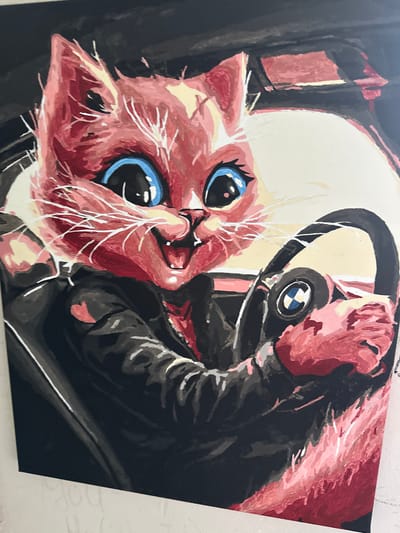 This is a close-up, eye-level painting of a pink cat wearing a black leather jacket and driving a car. The cat has large blue eyes, a wide open mouth with a pink tongue, and white whiskers. The steering wheel in front of the cat has a BMW logo on it. The background is dark and appears to be the interior of a car. The painting is rendered in a loose, expressive style with visible brushstrokes. The image is not located in the city of Podilsk, Ukraine.