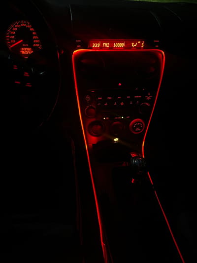 The image shows the interior of a car dashboard illuminated with red lights. The speedometer indicates a mileage of 349756 km and a trip mileage of 254.7. The radio is tuned to FM2 at 100.00 MHz, the time is 3:39, and the temperature is 5 degrees. Various car controls for the radio, air conditioning, and other functions are visible. The setting is dark, with only the illuminated elements readily discernible. There is no indication of Kribul, Bulgaria or people in the scene.