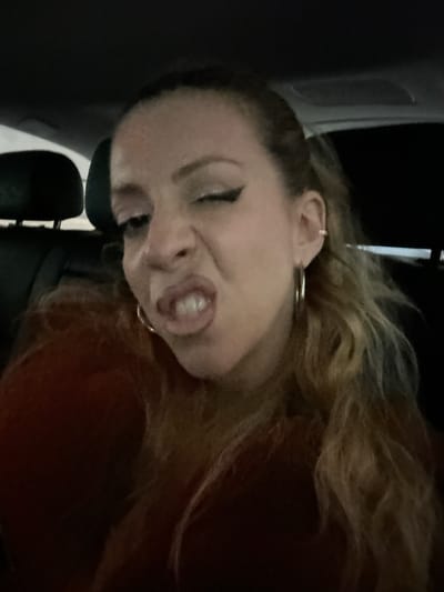A selfie-style image shows a woman with light brown hair and fair skin making a facial expression. She is wearing a silver hoop earring. Part of what appears to be the interior of a vehicle is visible on the left side of the frame. The location in Dartford, United Kingdom, cannot be determined from the image.