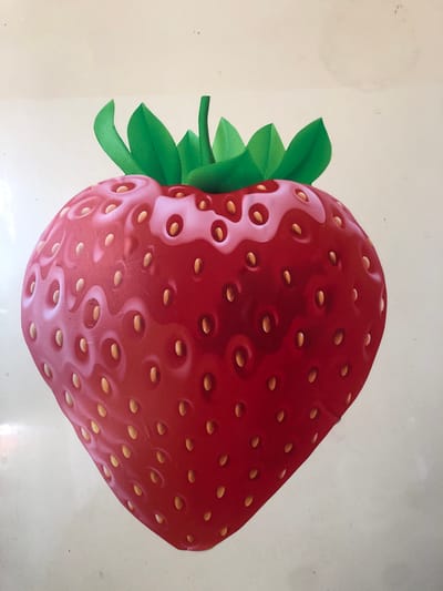 This media file features a close-up, overhead shot of a stylized, cartoon-like strawberry. The strawberry is depicted in a vibrant red color with a glossy finish, featuring numerous small, light-yellow seeds embedded in its surface. The fruit has a rounded, plump shape and is positioned slightly off-center, angled towards the upper right of the frame. To the left of the strawberry, a cluster of bright green leaves is visible, suggesting the stem and foliage.
The background is a plain, light cream or off-white color, with some subtle smudges and faint circular marks, possibly indicating wear or dirt on the surface the strawberry is resting on. The lighting appears to be even, with no strong shadows, suggesting an indoor setting or an overcast day. There is no discernible text in the image. The overall impression is of a graphic or illustrative representation of a strawberry, rather than a photograph of a real fruit in a natural setting. The image is static, with no activity or event taking place. The location context of Sosnovka, Russia, does not provide any specific visual cues within the image itself.