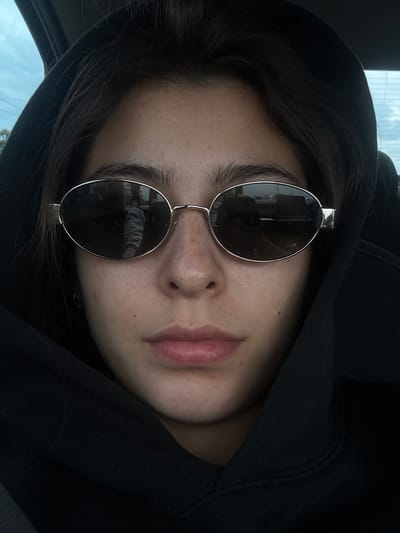 A person is wearing sunglasses and a black hooded sweatshirt. The location is possibly a car interior, but the city of Cucuyulapa, Mexico, cannot be confirmed.