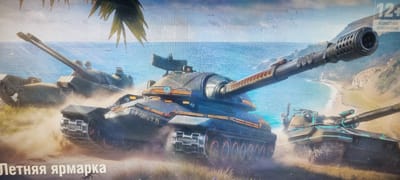 This media file depicts a scene featuring several futuristic tanks on a beach, with the ocean and a tropical coastline in the background. Palm fronds are visible in the upper left corner, suggesting a warm climate. The tanks are dark gray with bright orange and teal accents, and some are kicking up dust, indicating movement. In the upper right corner, a "12+" age rating is displayed, along with text that appears to be in Cyrillic script, possibly indicating "age restriction."
At the bottom left of the image, in large Cyrillic lettering, is the text "Летняя ярмарка," which translates to "Summer Fair." This suggests that the image is promotional material for a summer event, possibly related to a video game or a themed festival. The overall mood is dynamic and action-oriented, with the tanks appearing ready for combat. The lighting suggests it might be daytime, with a clear sky visible above the clouds. The presence of the beach, ocean, and palm trees points to a coastal, possibly tropical, or Mediterranean-like setting.