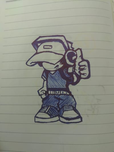 The image shows a hand-drawn cartoon character on lined paper. The character is wearing a baseball cap, a t-shirt with diagonal hatching, a belt with a rectangular buckle, and baggy pants. The character is also wearing sneakers. The character's right arm is raised, and they are giving a thumbs-up gesture. The drawing is done in blue ink with dark blue outlines. The paper appears to be from a notebook, with horizontal blue lines. There are no discernible elements in the image that would indicate a specific location in the city of Kamen, Germany.
