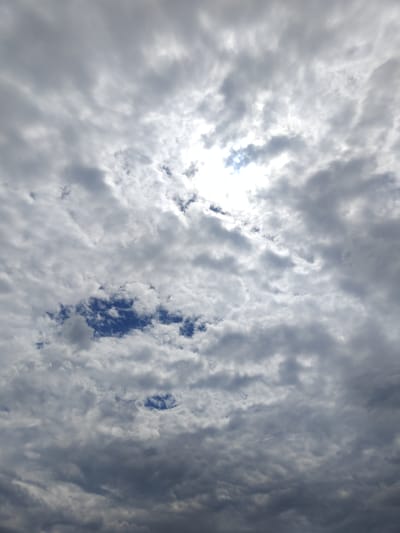 The image depicts a cloudy sky over the city of Colonița, Moldova. The sky is filled with a mix of light and dark gray clouds, with patches of bright blue sky visible in some areas. The sun is partially obscured by clouds, creating a diffused light. There are no people, subjects, objects, or actions visible in the image, only the natural phenomenon of the sky. The scene is a snapshot of the atmospheric conditions in Colonița.