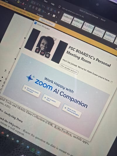 A computer screen displays a Microsoft Word document titled "God of Second Chances," with Word's formatting tools visible on the left. The document shows a Zoom meeting interface with the text "PSC BOARD1C's Personal Meeting Room," indicating someone has joined the call. Below, a "Zoom AI Companion" graphic features options like "Summarize recent messages," "List my action items," and "Show me the meeting highlights." The Word document also includes text about "Digital Tools and Mobile Data Collection (ODK, Kobo Toolbox, mobile apps)" and "Analyzing Data," suggesting a report or guide.