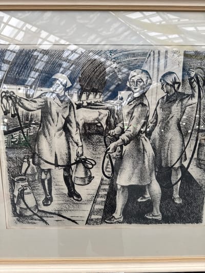 This is a black and white print depicting three figures in a dynamic, possibly chaotic scene. The style suggests an etching or woodcut with bold lines and heavy shading.
The subjects appear to be people, possibly men, dressed in what looks like utilitarian clothing or uniforms, including caps or head coverings. One figure is in the foreground, lying down and holding a rope or whip. Another figure is seated or kneeling above them, also holding a rope. The third figure is at the top, seemingly in motion, with an arm raised. The figures are depicted with strong musculature and an intense, perhaps strained, expression on their faces.
Objects in the scene include what appear to be ropes, possibly associated with pulling or working animals, and some cylindrical objects at the bottom, which could be tools or equipment. The background is abstract and filled with hatched lines, suggesting a confined or industrial setting, perhaps a stable, workshop, or a scene of labor.
The overall impression is one of strenuous activity, struggle, or an organized but intense task. The lighting is not clearly defined, but the stark contrasts created by the printmaking technique suggest a dramatic, possibly harsh environment. There is no visible text in the image. The location context provided, посёлок 1-го отделения совхоза "Масловский", Russia, suggests a rural or agricultural setting, which could align with the depiction of labor, though the specifics of the scene are not immediately identifiable as such.