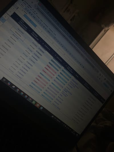 The image shows a close-up, angled view of a laptop screen displaying a spreadsheet. The spreadsheet appears to be a content calendar or project management tool, with columns for "SOCIAL MEDIA," "PROXIMA PUBLICACIÓN," "CONTACTO," "EJECUTIVO," "CANAL DE PUBLICACION," "REDES," and "LOGO Y DESTACADAS." The entries visible include dates like "26/6/2026" and "29/6/2026," names like "MARIO" and "CANDE," and company or brand names such as "Integral Dental," "Clínica Dental," and "Star Dental Group." The text "PROXIMO DISEÑO" is repeated in several cells.
The screen is partially illuminated, and the surroundings are dark, suggesting it might be evening or the room is dimly lit. A portion of a hand is visible at the top of the image, appearing to be resting on the laptop. The lower right corner of the screen shows system information: "19°C Nublado," "ESP," and the date and time "08:37 30/06/2026." The overall scene depicts someone working on a digital project, likely related to social media management or marketing, in a low-light environment. The location context provided is San Luis, Peru, although there are no direct visual cues in the image to confirm this location.