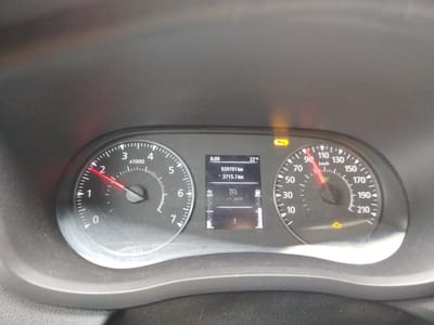 The image shows the dashboard of a car. A tachometer on the left indicates engine RPMs, with the needle pointing to approximately 1500 RPM. A speedometer on the right shows the vehicle's speed at approximately 40 km/h. In the center digital display, the time is 8:09, the outside temperature is 22°C, the odometer reads 939701 km, and the trip meter reads 3715.1 km. There are also several warning lights illuminated, including what appears to be a tire pressure warning light and a fuel level indicator showing the tank is nearly full. The dashboard is made of dark gray plastic and appears somewhat dusty. The image was taken indoors, likely inside the car. There is no information in the image to suggest the location is Königs Wusterhausen, Germany.