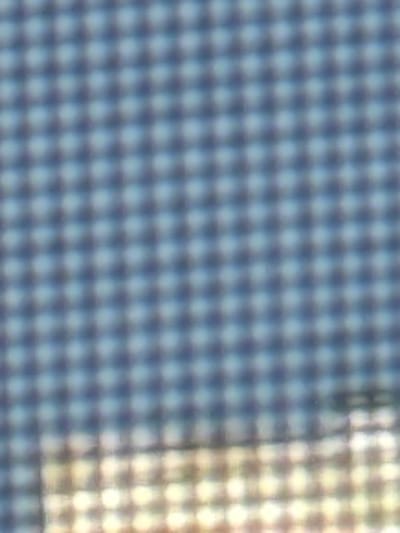 The image displays a blurred, grid-like pattern that is likely a close-up of a textured surface. The pattern consists of small, circular or diamond-shaped areas. These areas are alternately dark blue and lighter blue or white, creating a distinct checkerboard effect. On the right side of the image, the pattern transitions to areas of yellow and white light, suggesting a light source or a different material. The overall impression is one of abstract texture rather than a recognizable scene or objects. There is no discernible text, people, or specific activity visible. The extreme blurriness makes it impossible to determine the exact nature of the surface or its surroundings, but the repeating pattern suggests it could be a fabric, a screen, or some kind of decorative paneling. The location context of Морозовка, Russia, does not provide any specific visual cues within the image itself.