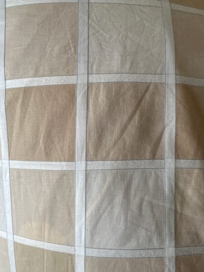 The image shows a close-up view of a beige fabric with a plaid pattern. The plaid is created by alternating shades of beige and white stripes, forming squares and rectangles. The fabric appears to be textured and slightly creased, suggesting it may be a curtain, upholstery, or bedding. There are no people or other objects visible in the image. The location in the city of Bad Blankenburg, Germany, is not identifiable from the provided image.
