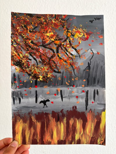 This is a horizontal, close-up shot of a painting on paper, held by a person's hand. The painting depicts an abstract autumn scene. On the left, there is a tree with vibrant red, orange, and yellow leaves, rendered with thick brushstrokes. The background is a stormy, dark gray, with some red and orange leaf-like shapes scattered throughout.

To the right of the tree, there are vertical brushstrokes of gray, suggesting tree trunks or perhaps the bark of birch trees. Black lines are painted across these gray areas, creating a segmented look. A small, black silhouette of a bird in flight is visible against the gray background.

The rightmost section of the painting features horizontal brushstrokes of dark brown, orange, and yellow, creating a textured, fiery effect, possibly representing flames or the intense colors of autumn foliage.

The overall impression is one of a dynamic and somewhat dramatic autumn scene, with a contrast between the fiery colors of the tree and the subdued grays and browns of the background. There are no visible text elements in the painting. The time of day and weather are implied by the dark, stormy gray in the background and the fiery colors, suggesting a dramatic or transitional moment in nature. The location context of Nienburg/Weser, Germany, would place this scene in a European setting during the autumn season.