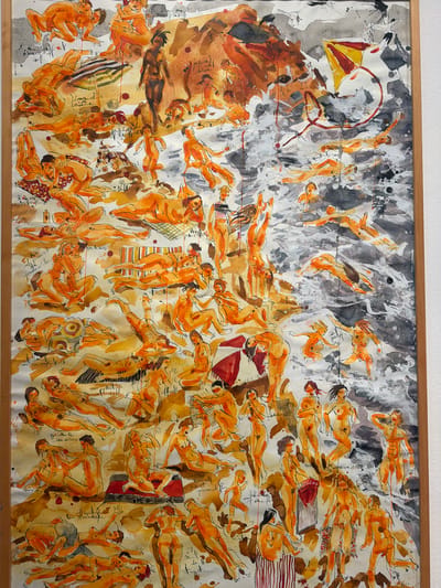 The image is a watercolor painting depicting a busy beach scene populated by numerous nude figures. The figures are rendered in shades of orange and brown, with loose, expressive brushstrokes. They are engaged in various activities: sunbathing, interacting with each other, and playing in the water. Some figures are lying on towels, while others are standing or in motion. Beach umbrellas and a kite are visible in the background, adding to the atmosphere of leisure. The water is represented with washes of gray and white, suggesting waves and movement. The overall impression is one of vibrant energy and a lively gathering. The location in the city of La Cuesta, Spain, is not discernible from the artwork itself.