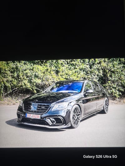 The image shows a black car parked on an asphalt road, with green bushes visible on the left. The car has a license plate with the identifier "BOT 06238." The image includes the text "Galaxy S26 Ultra 5G" on the right side. The location, Barutin, Bulgaria, is not directly discernible from the image but is specified in the prompt. No people are visible.