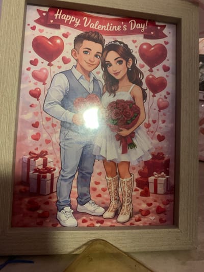 This media file is a framed, romantic illustration for Valentine's Day. The artwork depicts a couple in a whimsical, heart-themed setting. The female subject, on the left, is wearing a white dress and white boots with intricate gold patterns, holding a bouquet of red roses. She has dark hair and a gentle smile. The male subject, on the right, is dressed in a light blue suit and white sneakers, holding a heart-shaped object. He has short dark hair and a friendly expression. The background is adorned with numerous red and pink hearts, some appearing as balloons, and wrapped gift boxes with red ribbons. The overall tone is joyful and celebratory. The visible text on a red banner reads "Happy Valentine's Day!". The lighting suggests daytime, and there are no specific weather or location cues beyond the generic Valentine's Day theme.