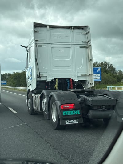 The image shows the rear of a white DAF truck driving on a highway. The truck has a license plate that reads "4-HA-808". There is a blue sign on the right side of the highway with an arrow pointing right and text that appears to say "ald's iplaats". The sky is overcast. The truck is likely located on a highway near Meppel, Netherlands, given the Dutch license plate and potential signage.