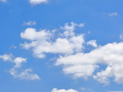 The image is a daytime, exterior, medium shot of a clear blue sky with scattered white cumulus clouds. There are no buildings, people, or other objects visible. The weather appears to be fair. The scene is consistent with an outdoor environment and does not provide any specific information about the location within Фронтовики Снт, Russia.