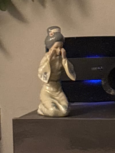 A statue of a World War I soldier is mounted on a black plaque or stand. The statue is cream colored and depicts a soldier holding a water bottle or canteen. A metal loop is above the statue. The statue appears to be displayed inside a building on a wall. It's not possible to verify the location in North Tyneside, United Kingdom, based solely on the image.