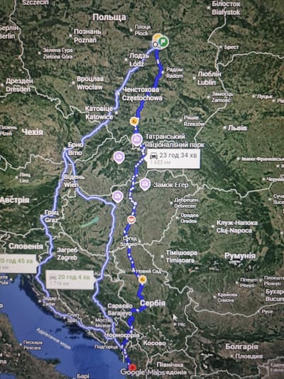 This is a screenshot of a navigation application, likely Google Maps, displaying a route across Eastern Europe. The route starts in Szczecin, Poland, and proceeds eastward through various Polish cities including Plock, Lodz, Radom, Lublin, and Chelmno. It then crosses into Ukraine, passing through Lviv, and continues into Romania, with a stop in Cluj-Napoca. From Romania, the route moves south into Serbia, then through Croatia, with stops in Zagreb and Split, and finally appears to end in or near Italy, with Pescara visible.
Several cities are clearly labeled in both Polish and English, such as Bialystok, Brest, Zamosc, Katowice, Wroclaw, Rzeszow, and Timisoara. Other labeled cities include Vienna (Austria), Graz (Austria), Sarajevo (Bosnia and Herzegovina), and Mostar (Bosnia and Herzegovina). Some segments of the route are marked with estimated travel times and distances. For example, one segment shows "23 год 34 хв" (23 hours 34 minutes) for a distance of "1 653 км" (1,653 km). Another segment indicates "20 год 45 хв" (20 hours 45 minutes) and "20 год 4 хв" (20 hours 4 minutes) with distances of "1 716 км" (1,716 km).
The map's satellite view shows a green and brown landscape, indicating diverse terrain with forests and mountains, particularly in the southern portions of the route in the Balkans. There are no people or specific objects visible beyond the map interface itself and the route markers, which are represented by circular icons. The image quality is somewhat grainy, suggesting it's a photograph of a screen. The lighting appears to be from overhead, typical of indoor environments. The overall impression is a detailed logistical plan for a long-distance road trip.
