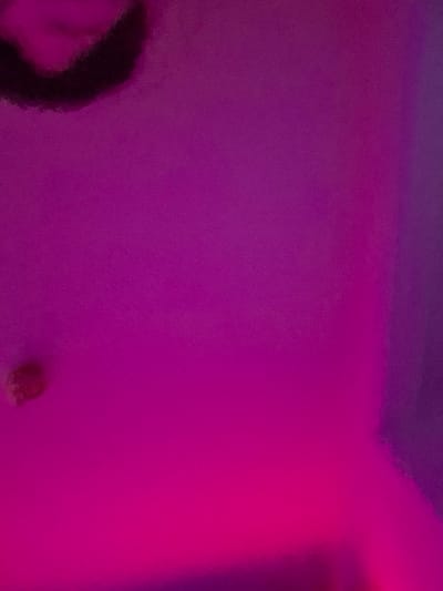 The image is of a solid, uniformly colored, magenta wall with a blurred image of a person's face and the top of their head in the upper left-hand corner. There are no other objects or people in the image. The image is likely from the interior of a building. The coordinates 51.886, 11.048 are located in Halberstadt, Germany, but the image does not provide any information about its location in Halberstadt.