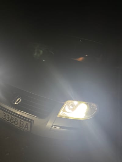 The image shows the front of a vehicle at night, its headlight brightly illuminating the scene. The vehicle has a license plate with the characters "3388 BA" visible. The environment is dark, with a hazy or foggy atmosphere. The vehicle grill and emblem are partially visible. There are no people immediately apparent in the image. There's no explicit visual evidence to confirm the location in Grohotno, Bulgaria.