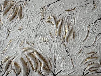 The image displays an abstract, textured artwork with a white base. Black, vine-like lines are overlaid on the white surface, interspersed with streaks of gold leaf. The texture of the white material appears rough and undulating, creating shadows and highlights that give it a three-dimensional quality. There are no discernible people, specific objects, or actions depicted, and the context of Užliekniai, Lithuania, is not visually represented in the artwork itself.