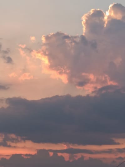 This media file captures a dramatic sky filled with clouds during what appears to be sunset or sunrise. The dominant subjects are the clouds themselves, illuminated by warm, golden light that peeks through the top right portion of the frame. These clouds range in color from bright white and soft pink where the light hits them most intensely, to deeper greys and purples in the shadows. The overall scene is one of natural beauty, with the sky serving as the primary focus.

There are no visible people or man-made objects in the foreground or mid-ground, leaving the viewer to solely appreciate the atmospheric display. The setting is an outdoor environment, likely an open area given the unobstructed view of the sky. The time of day is strongly suggested to be either dawn or dusk, due to the presence of warm, low-angle sunlight and the soft, pastel hues coloring the clouds. The weather appears to be a mix of fair and overcast, with some parts of the sky clear enough to allow sunlight to break through dramatic cloud formations.

The mood evoked by the image is one of awe and perhaps tranquility, with the vibrant colors and majestic cloud formations creating a visually striking spectacle. The location context of Lozova, Ukraine, places this natural event within a specific geographical setting, though no specific landmarks are visible to pinpoint the exact spot. No text is present in the media file.