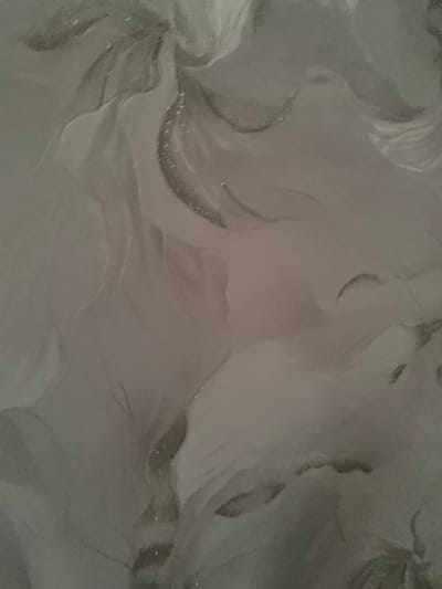 The image displays a close-up, abstract view of a gray, textured surface with subtle swirling patterns and variations in light and shadow. There are no discernible people, objects, or actions visible, nor is there any context provided about a specific location within Uzhur, Russia. The image appears to be a photograph of a material with a marbled or fluid-like appearance.