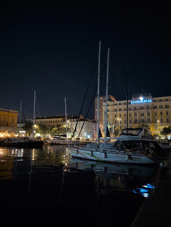 Rijeka harbor at night, sailboats and cargo ships docked