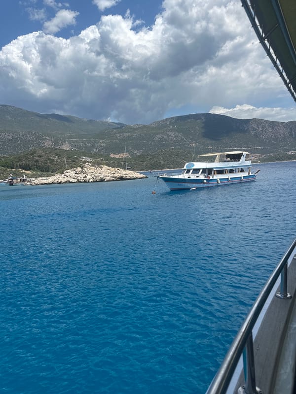 Peaceful coastal boating scene documented near rocky shoreline