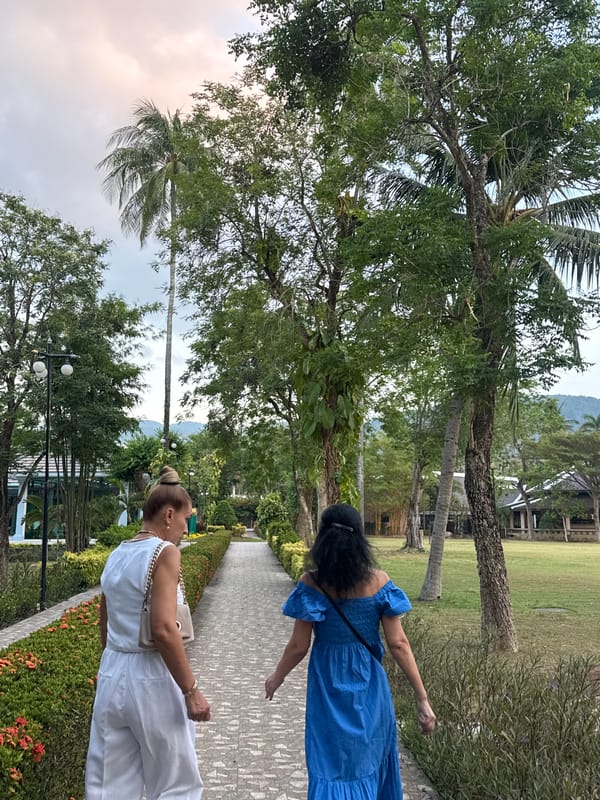 Two women stroll through scenic park in Patong, Thailand