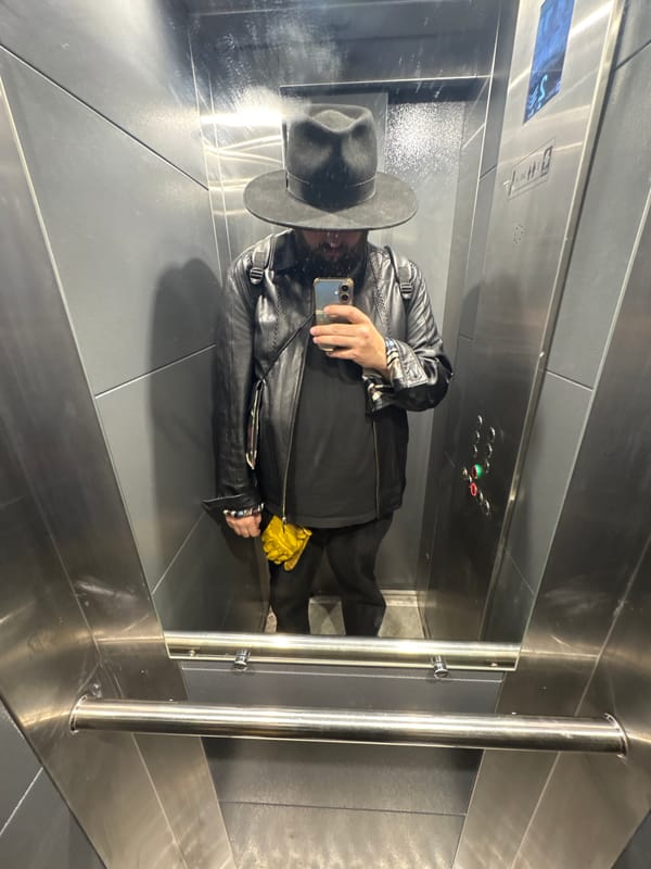 Person in hat and leather jacket photographed in Moscow elevator