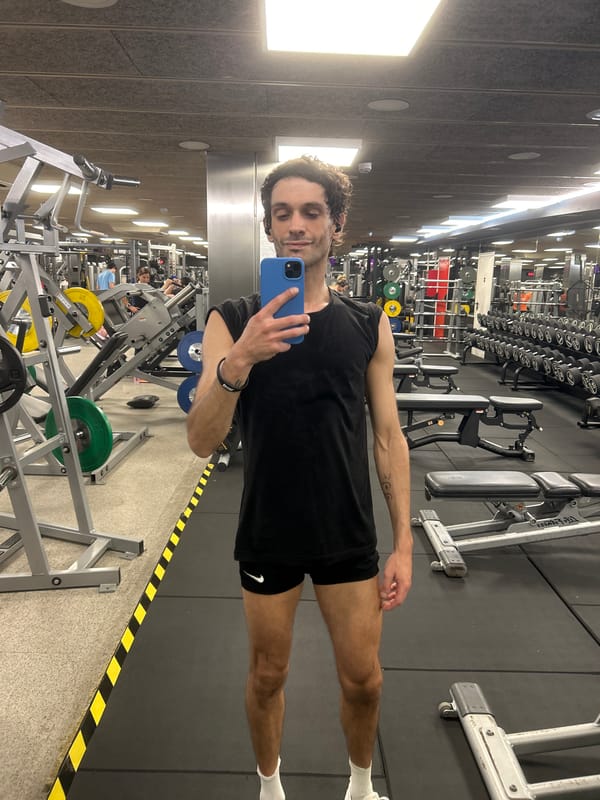 Mirror selfie at a Barcelona gym, weights in the background.