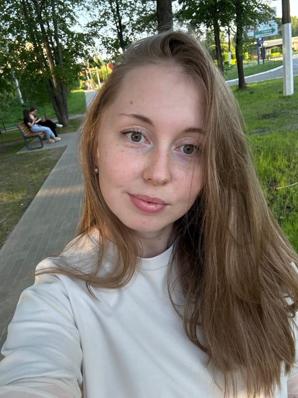 Woman enjoys afternoon park visit, takes selfies near Ferris wheel