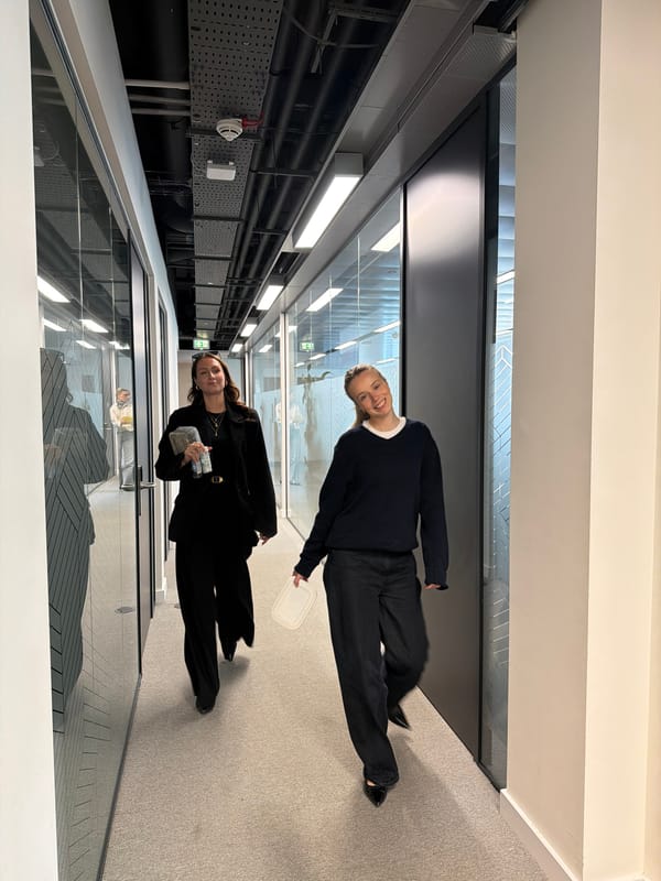 Two women photographed moving through London office building